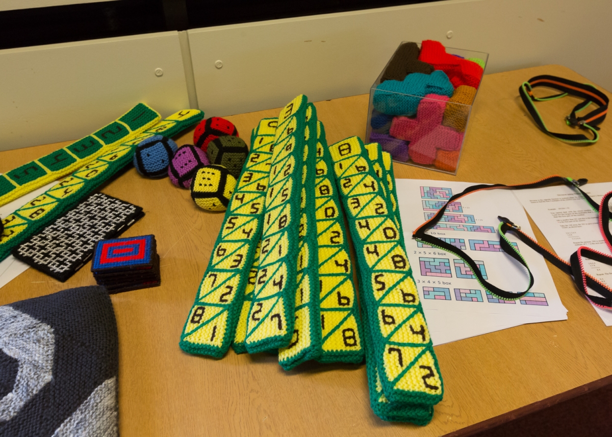 Knitted objects, including Napier's rods and Soma cube pieces, on a table.